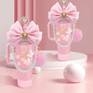 Set accessori per tazza rosa con grande fiocco catena di perle e ciondolo pompon di peluche.