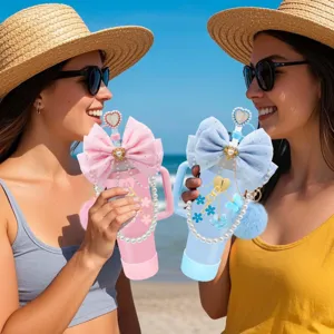 Stilvoller Thermobecher mit großer Schleife, Perlenkette und Strohhalm für den Strand.