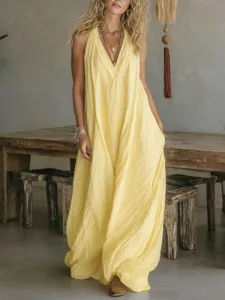 Detail shot of a casual yellow sleeveless halter long dress with loose fit and side pockets.