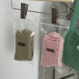 Close-up detail of soft wool blend crew socks in transparent packaging, cozy winter style.