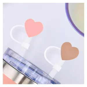 Dettaglio copri cannuccia in silicone a cuore, simpatico tappo antipolvere per tazze e bicchieri.