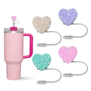Silicone heart-shaped straw covers and pink tumbler detail view, cute cup accessories.