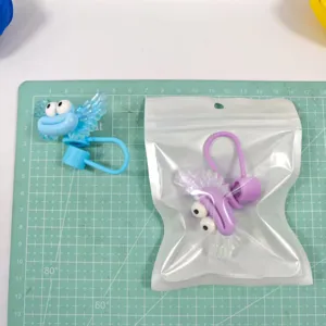 Close-up detail of cute funny cartoon straw cover with big eyes and acrylic wings.