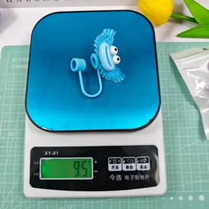 Detailed shot of the blue cute cartoon monster straw cover weighing 9.5g on scale.