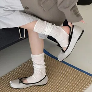 Detail shot of women's silver ballet flats and white socks, soft texture and comfortable daily wear.