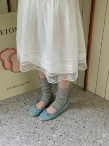 Gedetailleerd uitzicht op grijze geplooide sokken in Japanse stijl en ballerina's.