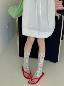 Gros plan sur les chaussettes en dentelle à pois transparentes, bas d'été élégants.