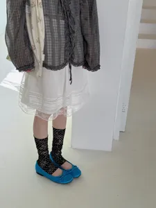Vue rapprochée détaillée de chaussettes en tulle à pois pour femme et de superbes chaussures.