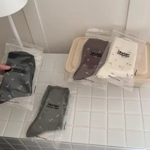 IOULOR retro floral mid-calf warm socks in individual packaging, cozy winter style detail.