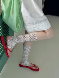 Vue détaillée de chaussettes étriers en dentelle à pois blancs, chaussettes en filet.