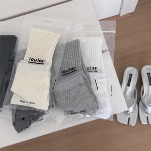 Detail shot of solid color stirrup socks in clear bags, featuring comfortable soft knit fabric.