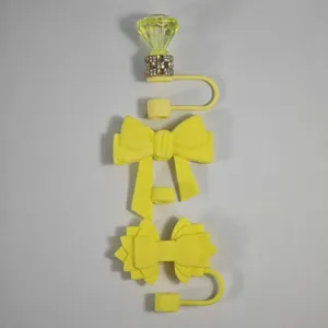 Yellow silicone straw cover detail showing diamond and bow straw topper designs clearly.