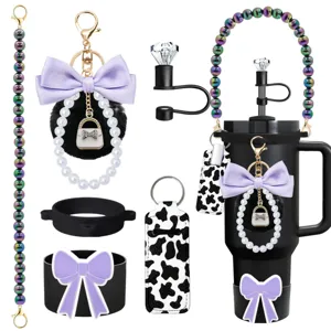 Detailed view of tumbler accessories set with pearl strap, bow pompom and cow print pouch.
