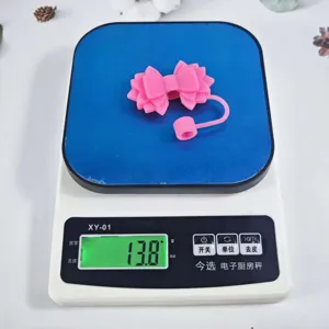 Pink silicone straw cover bow dust cap tumbler accessory detail view showing lightweight design.