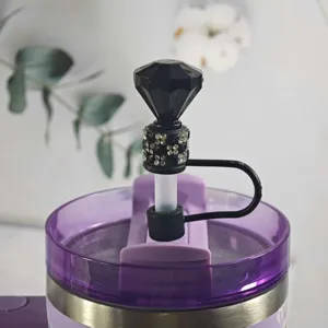 Detailed close-up of a black diamond rhinestone straw cover accessory for water tumblers.