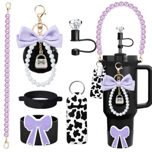 Detailed view of trendy cup accessories including pearl chain, bow keychain and straw topper.