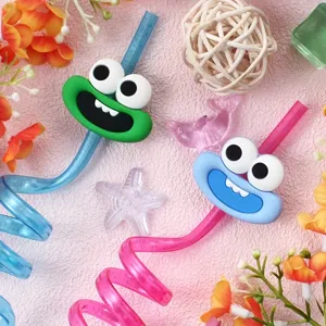Close up view of colorful cartoon spiral drinking straws with cute monster face designs.