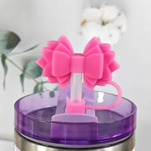 Pink silicone bow straw cover detail shot, dust plug accessory for tumblers and cups.