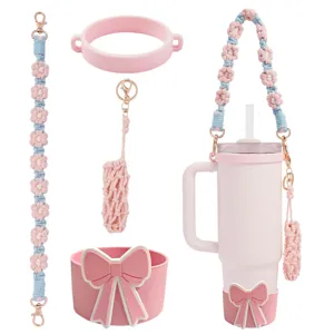 Pink tumbler accessory set with crochet daisy strap, bow silicone boot and lipstick pouch.