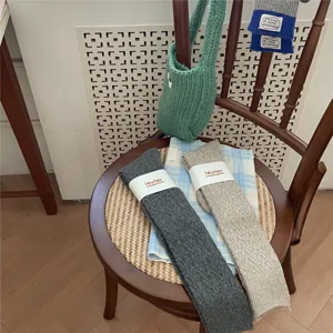 Detailansicht der IOULOR Retro Wollstrümpfe in Dunkelgrau und Beige, gemütliche Wintersocken.