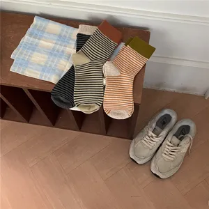 Detail view of cozy color-block striped mid-tube socks, featuring soft ribbed cuffs for autumn.