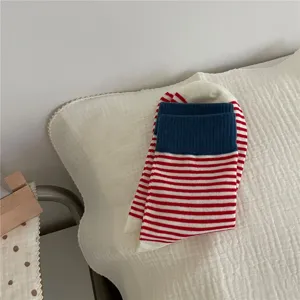 Close-up of stylish women's mid-tube striped socks with contrasting cuffs for cozy autumn wear.