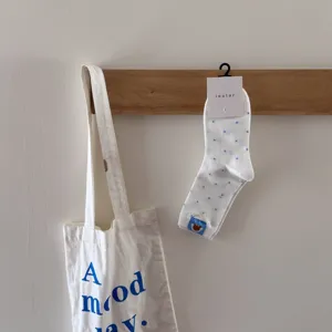 White cotton mid-tube socks with blue polka dots and cute dog embroidery, cozy style.