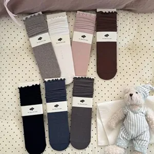 Detail view of solid color stacking socks in multiple colors with cute packaging tags.