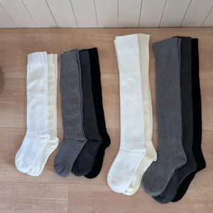 Detailed view of solid color long socks, cozy compression style for autumn and winter outfits.