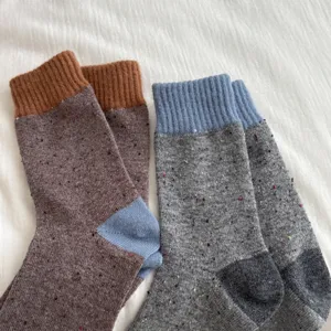 Merino wool color block socks detail shot, thick warm winter crew socks knit texture close up.