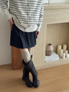 Knee-high slouch socks detail shot, cozy autumn winter knit style, premium fabric texture.