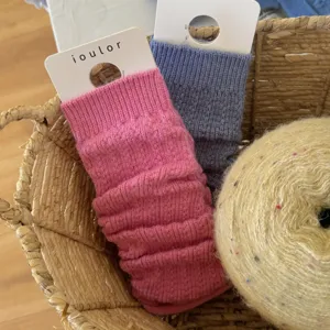 Detailed shot of cozy knitted leg warmers in a woven basket, featuring soft textured fabric.