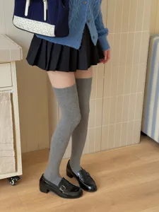 Grey over-the-knee socks styled with school uniform skirt and loafers for daily autumn wear.