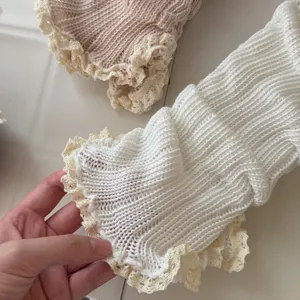 Detail view of sweet Y2K knitted leg warmers with delicate lace trim, soft texture and cozy style.