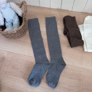 Solid color knee high socks detail view, comfortable knit long stockings for women daily wear.