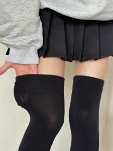 Details of black over-the-knee socks showing elastic top and anti-slip grip design.