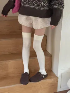 Comfortable white over-the-knee socks for women, preppy style autumn winter leg wear detail.