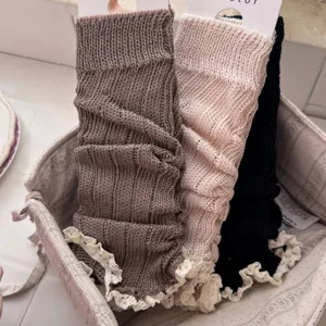 Chunky knit leg warmers with delicate lace trim, cozy winter slouch socks for women.