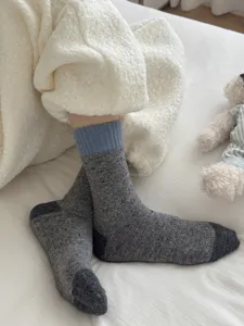 Cozy woolen mid-tube socks detail shot, showing soft grey speckled knit texture and blue rib cuff.