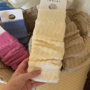 Detail shot of soft cable knit leg warmers in assorted colors, showcasing cozy texture.