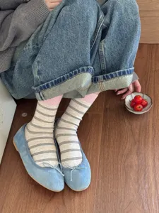 Close-up of Japanese style striped color-blocked mid-tube socks worn with casual shoes.