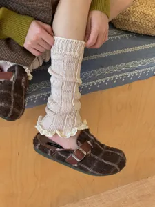 Detailed view of women knit leg warmers with lace ruffle, autumn winter cozy y2k aesthetic.