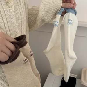 Dettaglio in primo piano di calze invernali lavorate a maglia con risvolto e ricamo carino.