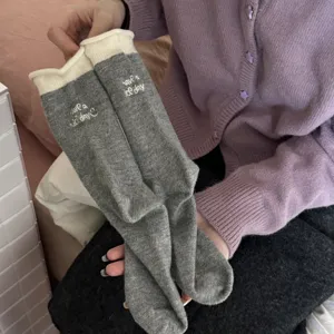 Primo piano di calze a metà gamba in maglia, design bicolore dolce, stile caldo invernale.