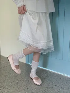 Gedetailleerde opname van Japanse sokken met ruches en zachte roze ballerina's.