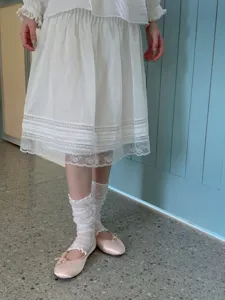Gedetailleerd overzicht van Japanse stijl franje beenwarmers en roze ballerina's.