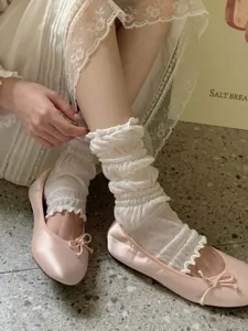 Gedetailleerd uitzicht op schattige Japanse sokken met volant en roze satijnen ballet schoenen.