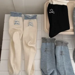 Calzini medi in maglia da donna con bordo arrotolato colore a contrasto e lettere ricamate invernali.