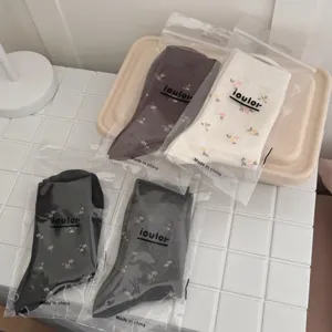 Detailed view of four pairs of vintage floral mid-tube socks in neat packaging, cozy and soft.