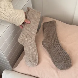 Close-up detail of cozy knit wool socks in neutral tones, soft texture for winter warm daily wear.